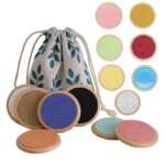 Joli sac en tissu blanc avec des fleurs bleus et des disques en bois sensoriels cognitifs pour développer les sens de bébé.