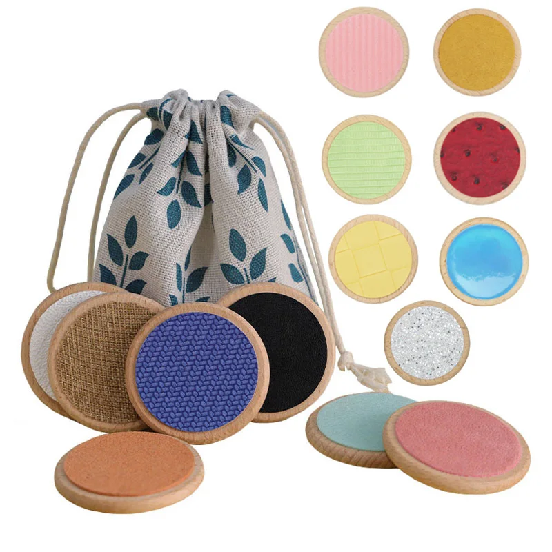 Jeu sensoriel Montessori pour bébé Joli sac en tissu blanc avec des fleurs bleus et des disques en bois sensoriels cognitifs pour développer les sens de bébé.