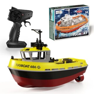 Bateau raciocommandé jaune type chalutier, à côté de sa boîte de jeu et de sa télécommande